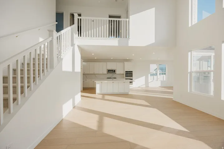 Open concept living space featuring wood-finish flooring and a two-story ceiling