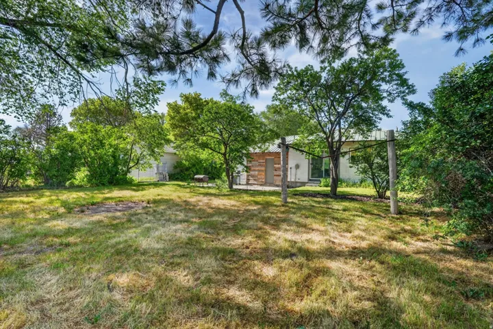 Expansive backyard with a sloped lawn and mature trees