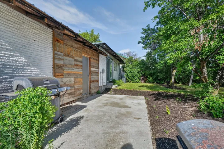 Concrete patio with wood paneling and corrugated metal siding