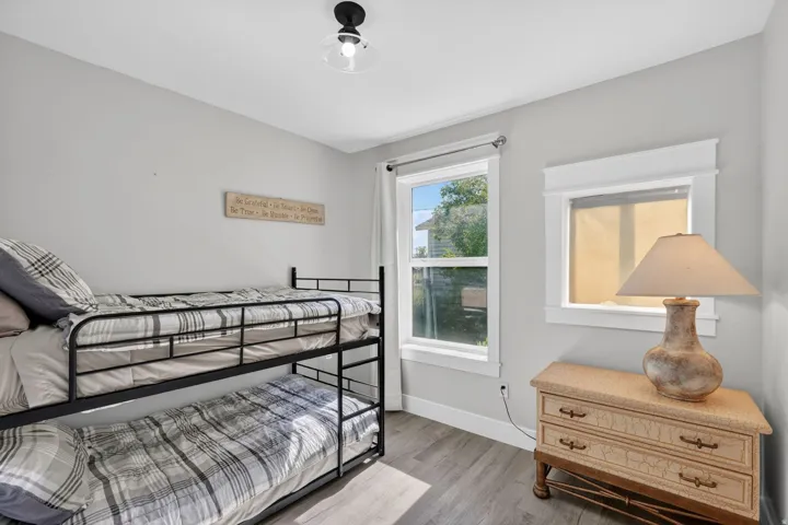 Light-filled interior space featuring two windows, wood-finish flooring, and a semi-flush mount ceiling fixture