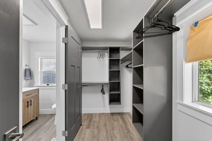 Spacious walk-in closet featuring extensive built-in shelving and hanging rods