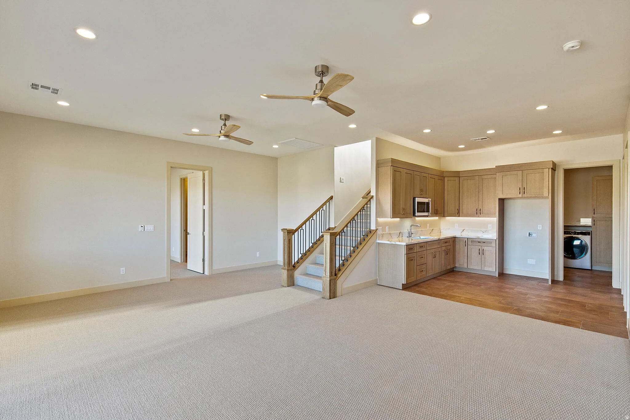 Lower level featuring a built-in wet bar with wood cabinetry, undermount sink, microwave, and under-cabinet lighting