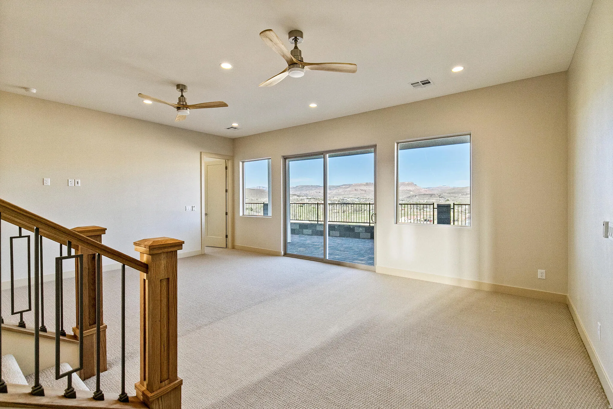 Spacious interior room with light-toned carpet flooring and neutral wall tones