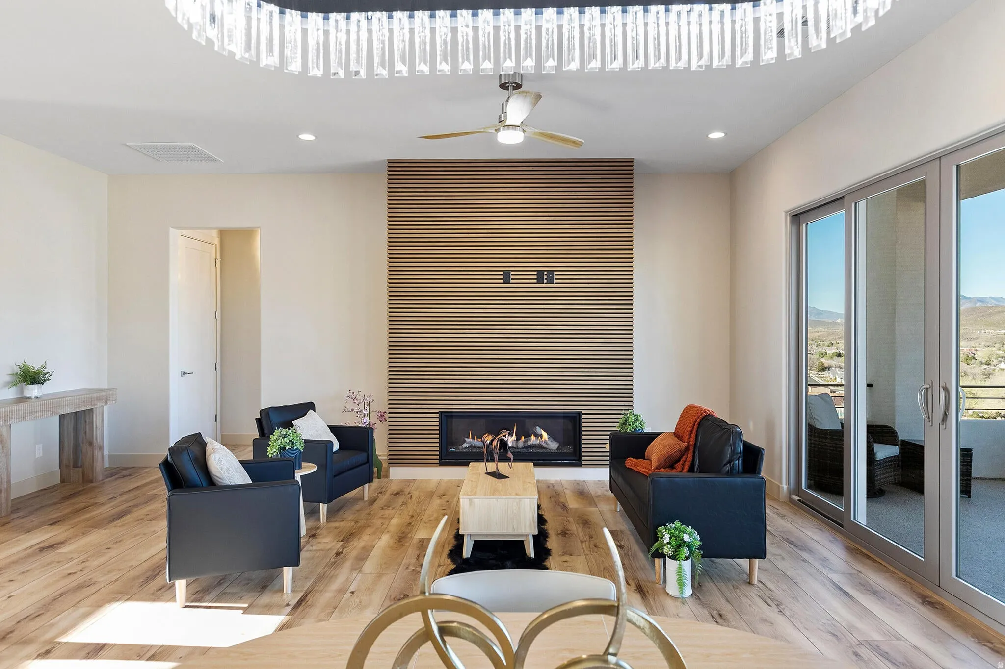 Spacious living area featuring wood-finish flooring and an accent wall with a built-in fireplace