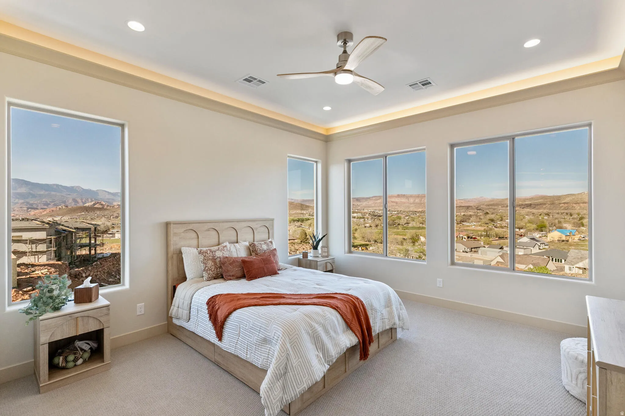 Spacious room featuring multiple large windows, recessed ceiling lights, a ceiling fan, and carpeted flooring