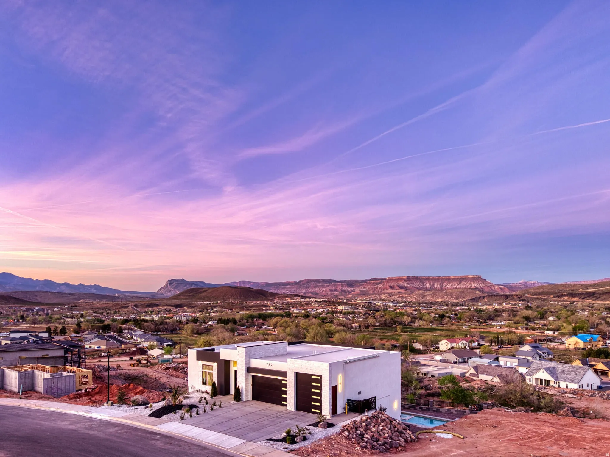 Modern architectural residence featuring a flat roofline, integrated garage, and a contemporary white stucco exterior