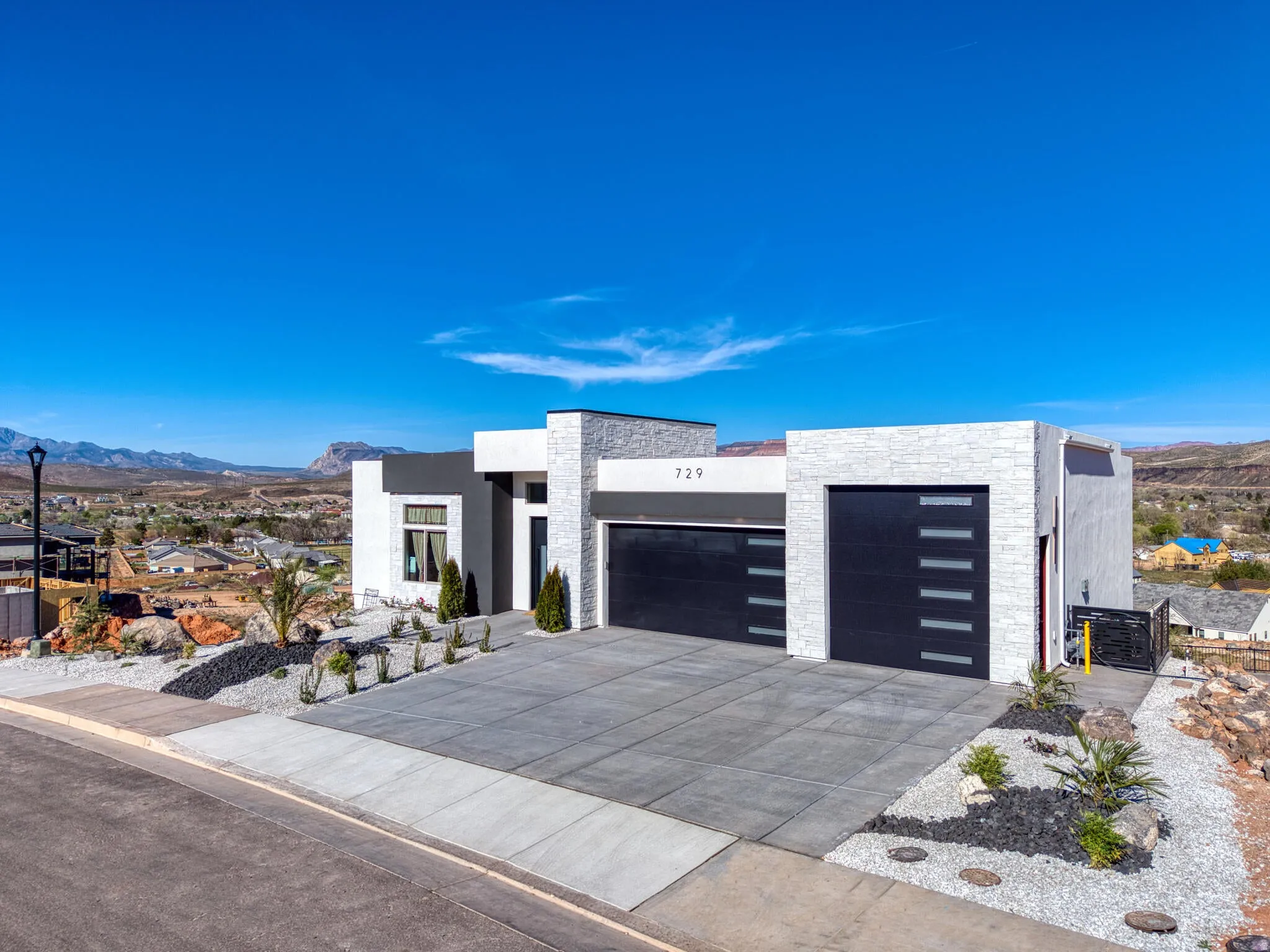 Modern architectural residence featuring a white stone facade and dark gray accents
