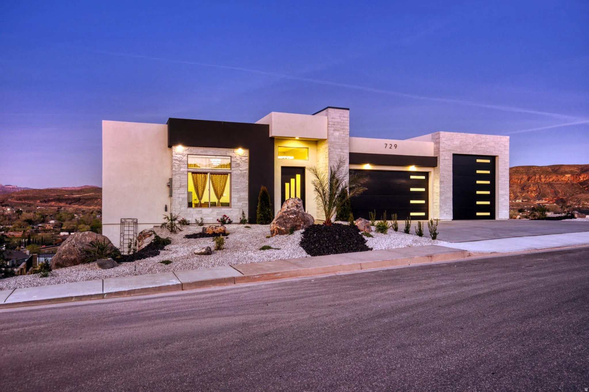 Modern architectural exterior featuring stone veneer accents, smooth stucco finishes, and dark horizontal siding