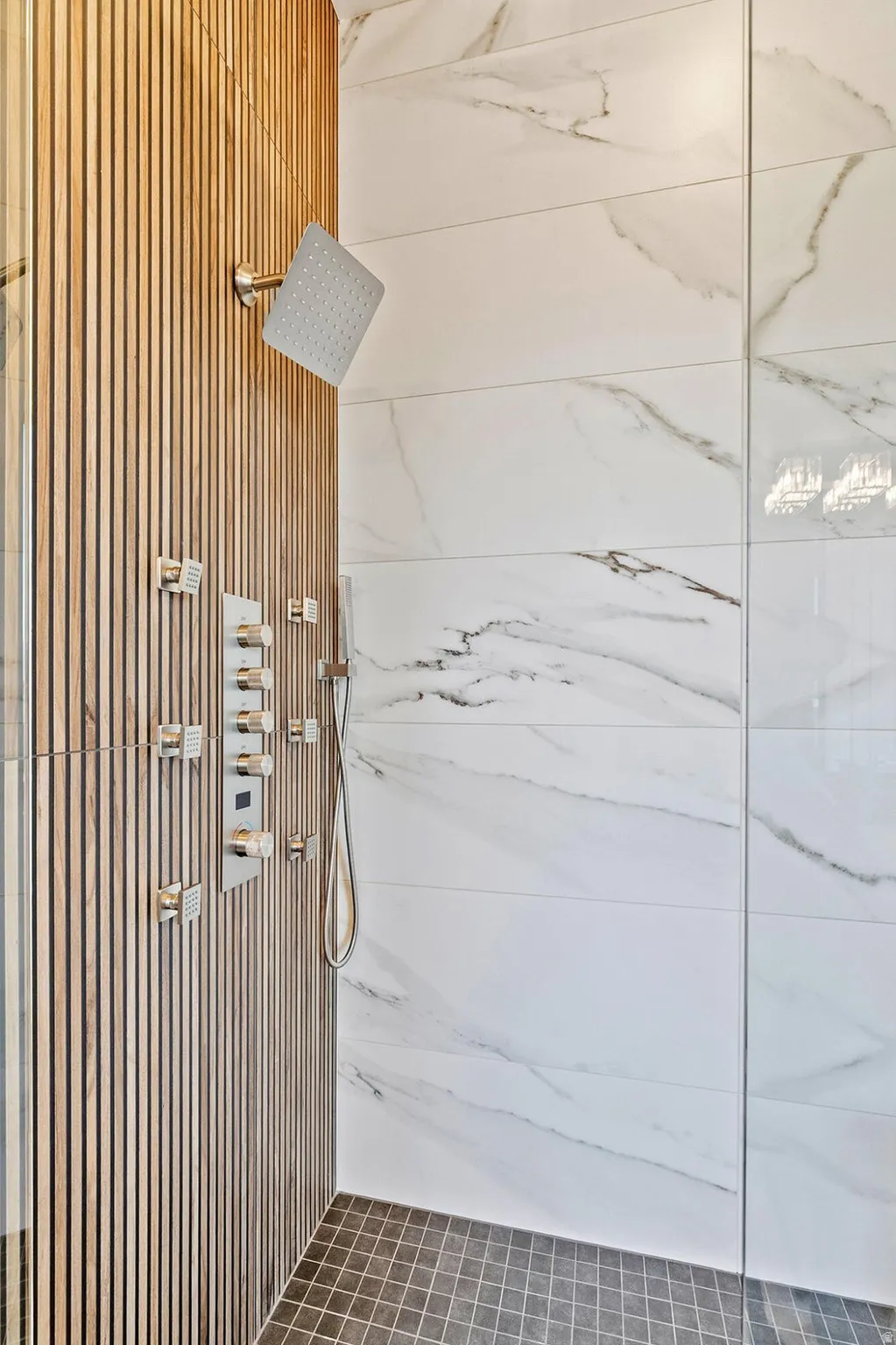 Contemporary shower enclosure featuring a wood-finish slat wall, square rainfall shower head, and an integrated multi-function shower panel with controls
