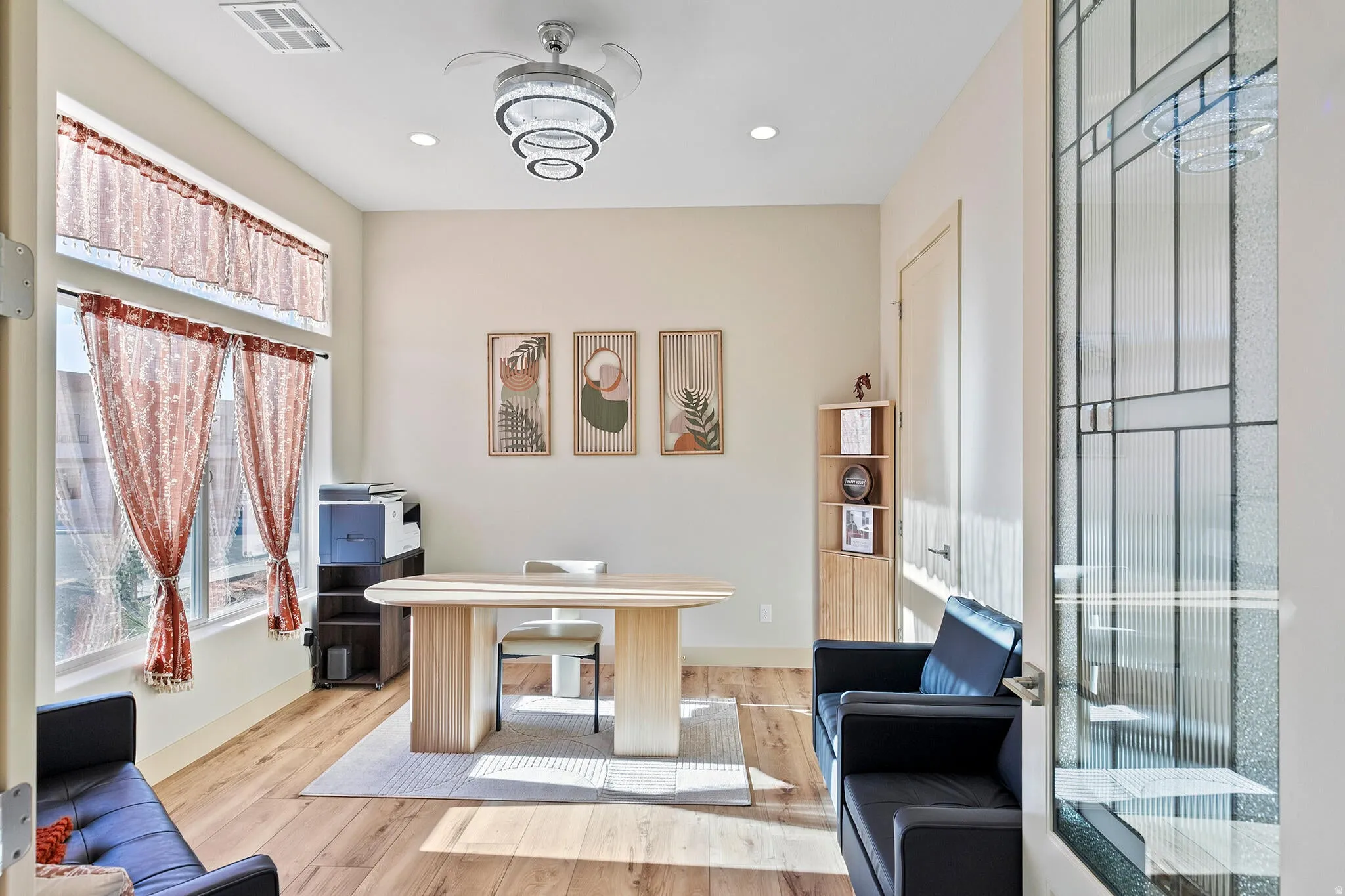 Versatile interior space featuring wood-finish flooring and a decorative chandelier with integrated ceiling fan