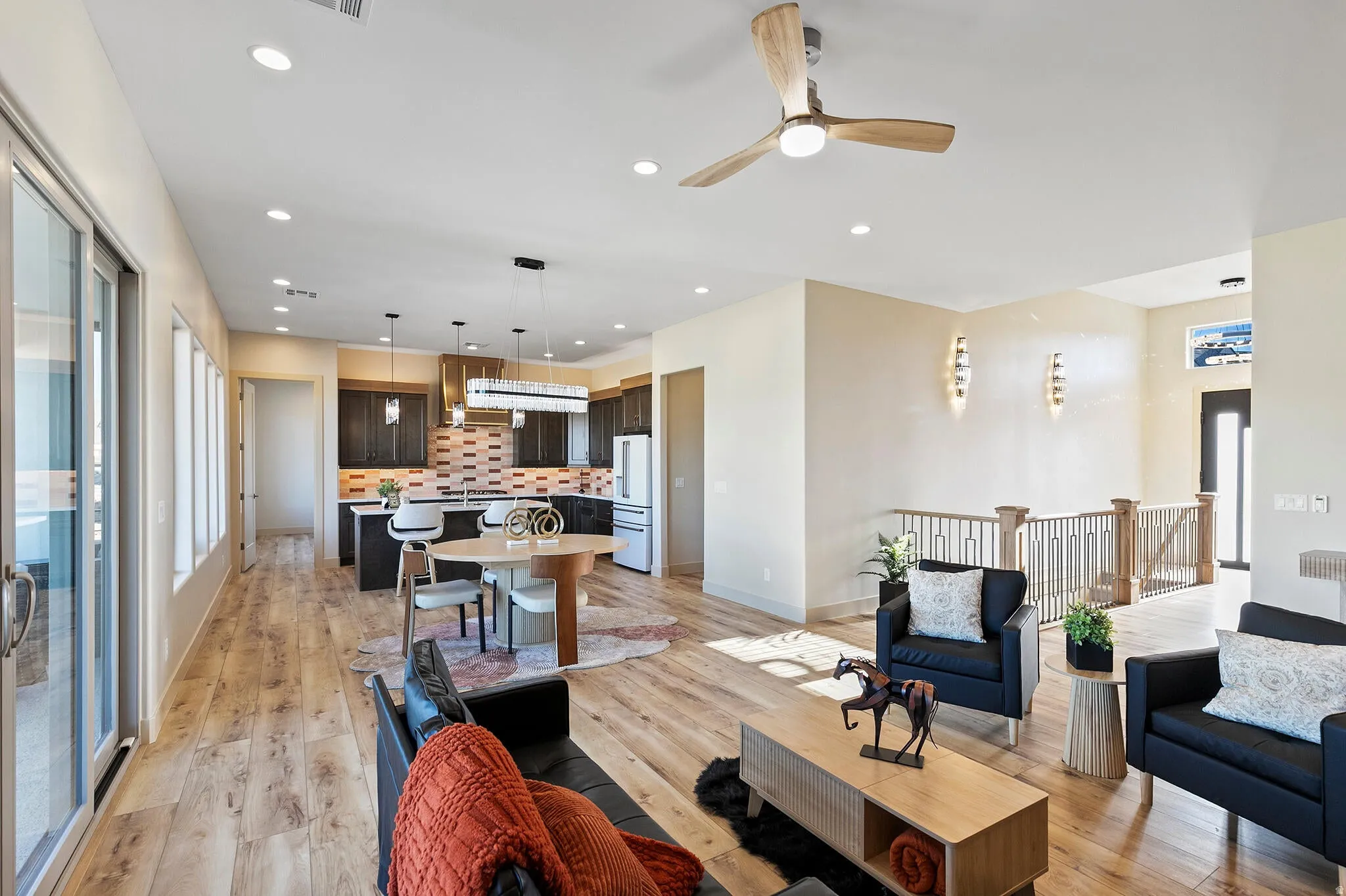 Open-concept living space featuring wood-finish flooring, recessed lighting, and a contemporary ceiling fan