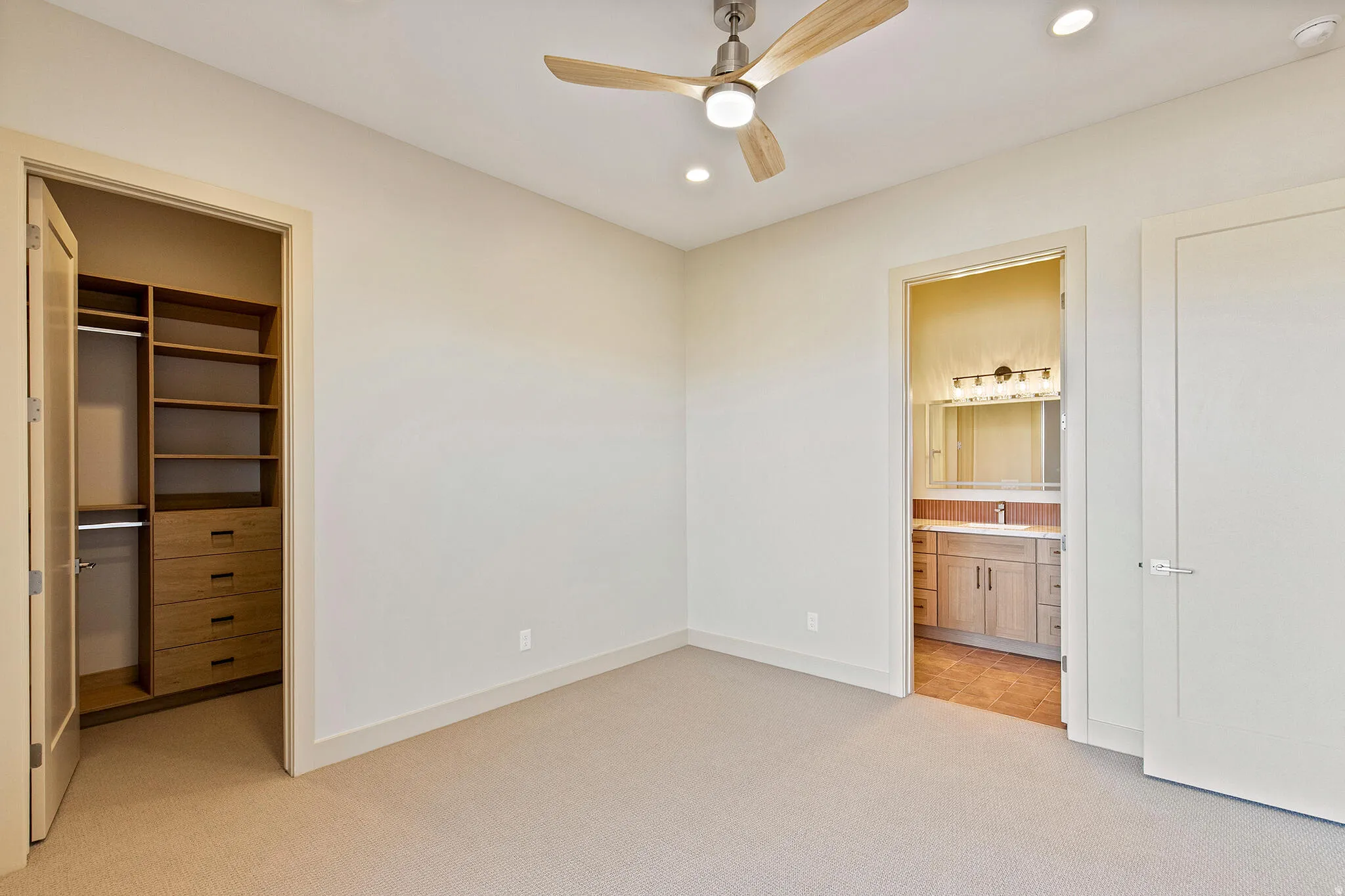 Neutral-toned room with plush carpeting and a modern ceiling fan with integrated lighting