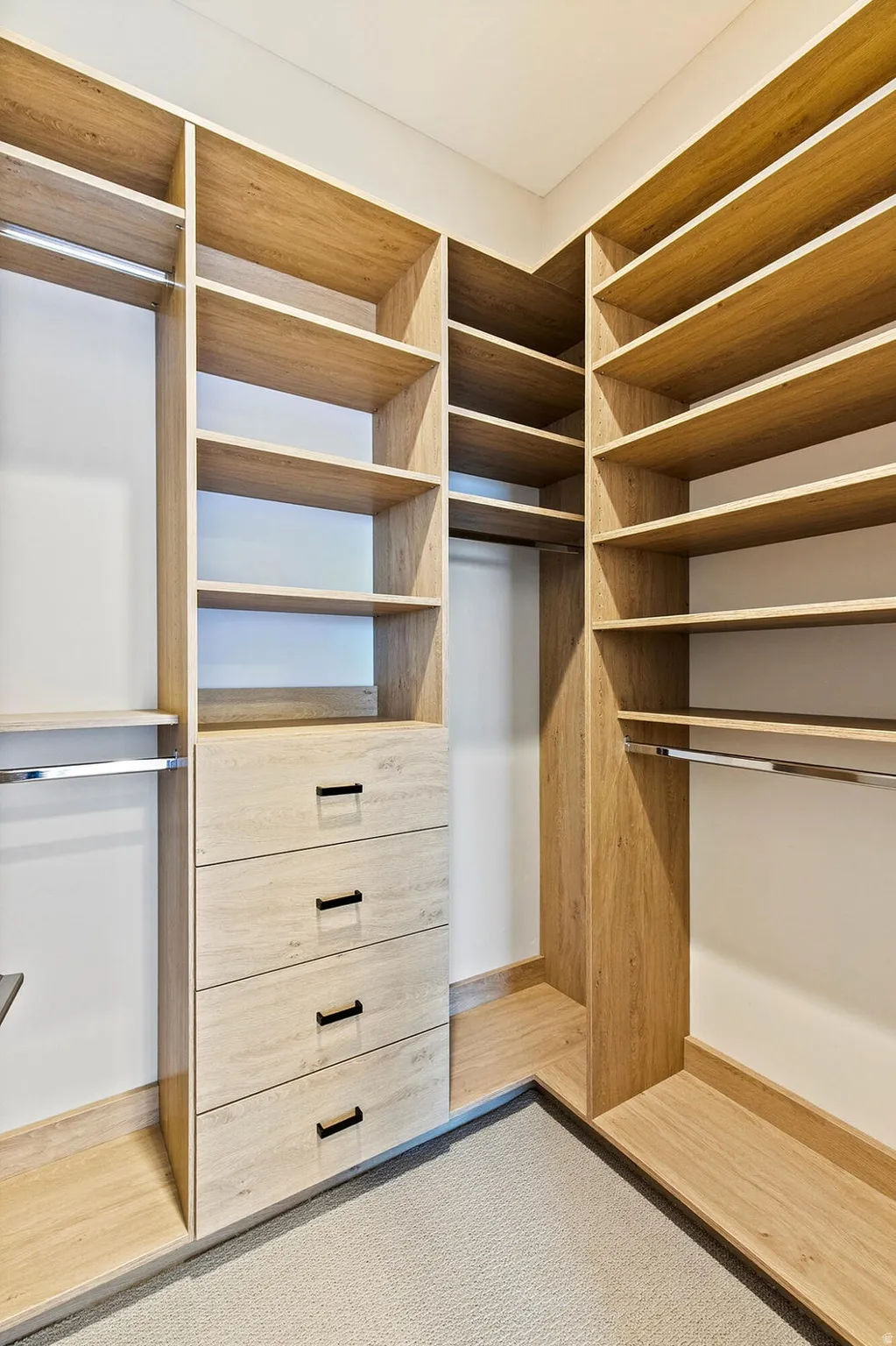 Custom closet system featuring light wood-finish shelving and built-in drawers