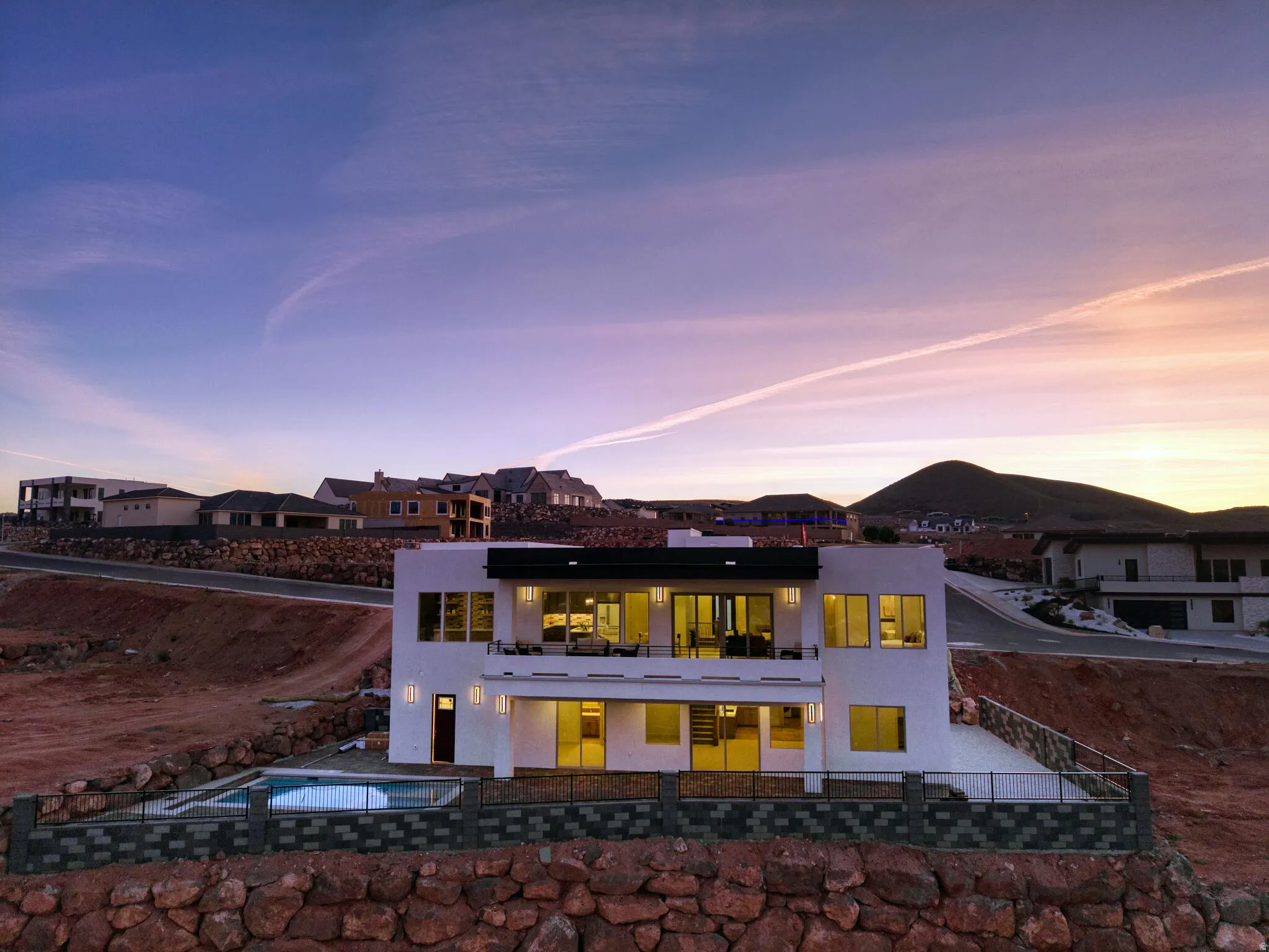 Contemporary multi-level residence featuring a white stucco exterior and black trim