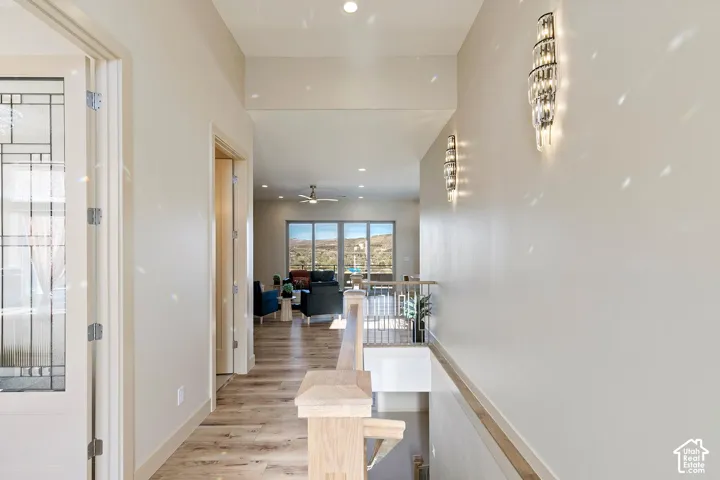 Hallway featuring wood-finish flooring, recessed lighting, and modern wall sconces