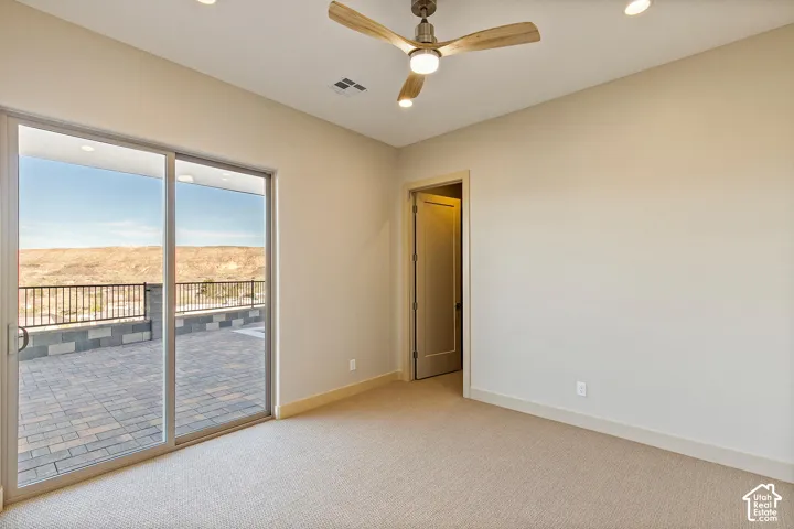 Spacious interior with neutral-toned walls, recessed lighting, and a ceiling fan with light wood-finish blades