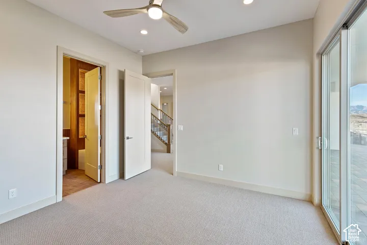 Carpeted room with a ceiling fan, recessed lighting, and a sliding glass door providing access to an outdoor patio