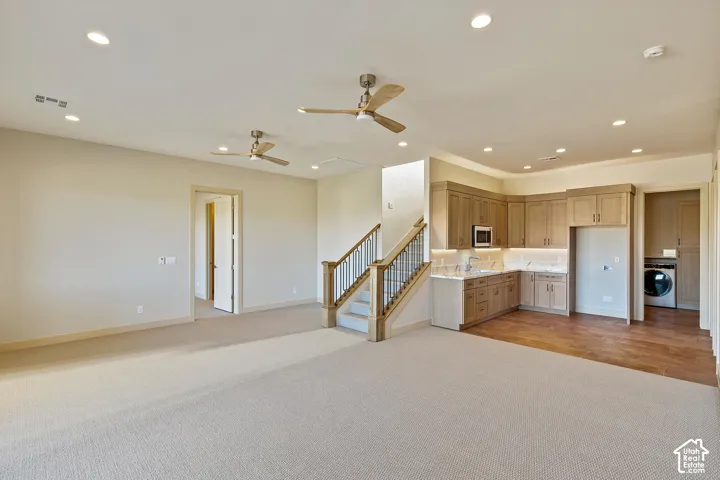 Lower level featuring a built-in wet bar with wood cabinetry, undermount sink, microwave, and under-cabinet lighting