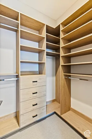 Custom closet system featuring light wood-finish shelving and built-in drawers