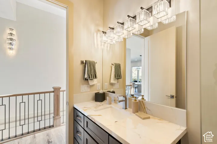 Vanity with a light-toned countertop, integrated rectangular sink, and polished chrome faucet