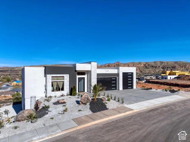 Modern facade featuring white stucco and stone accents