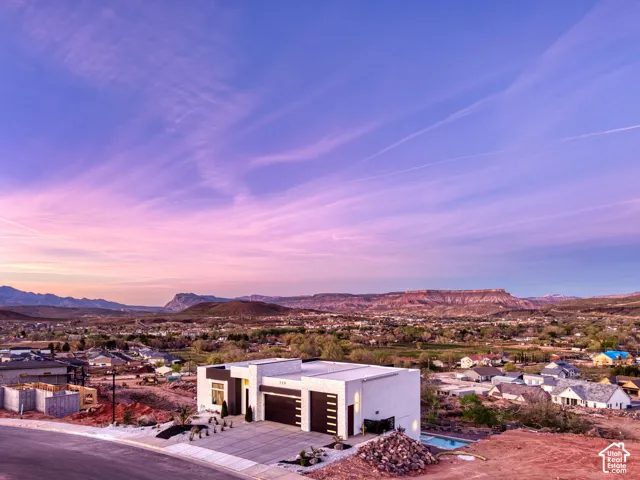 Modern architectural residence featuring a flat roofline, integrated garage, and a contemporary white stucco exterior