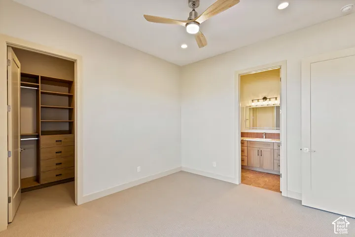 Neutral-toned room with plush carpeting and a modern ceiling fan with integrated lighting