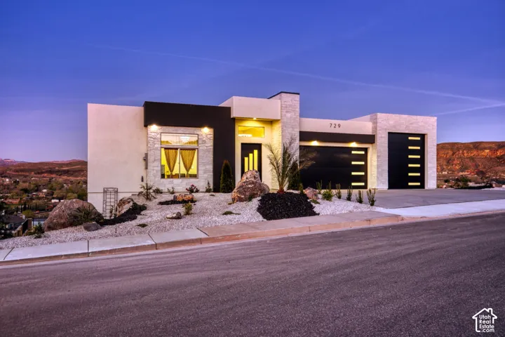 Modern architectural exterior featuring stone veneer accents, smooth stucco finishes, and dark horizontal siding