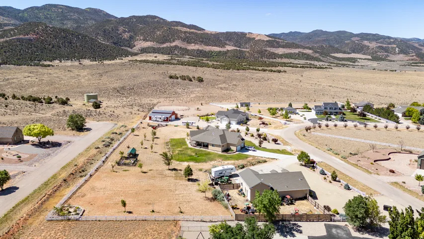 Expansive property featuring multiple single-story residences, paved and unpaved roadways, and surrounding arid landscape