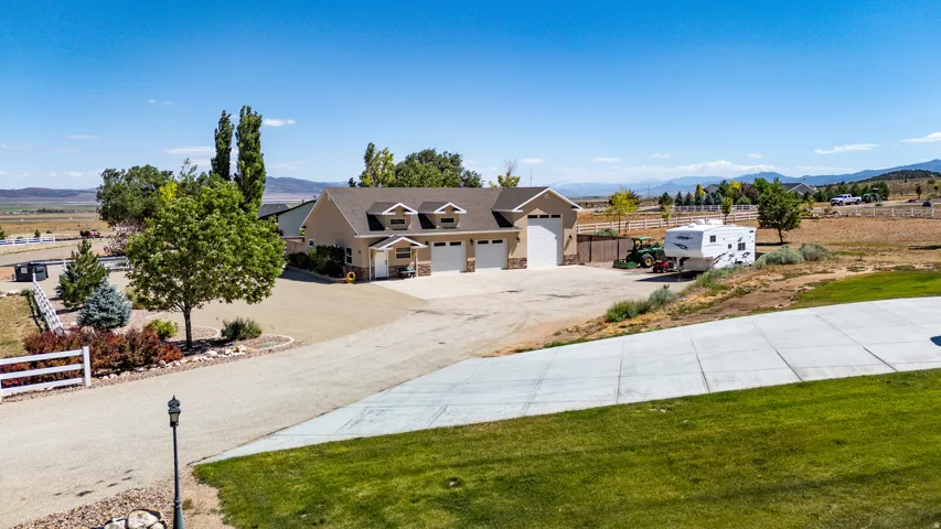 Single-story residence featuring a tan stucco exterior, multiple dormer windows, and an attached three-car garage