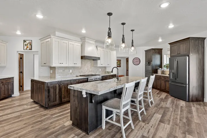 Contemporary kitchen featuring an expansive center island with seating, a gas range, and a full-size refrigerator