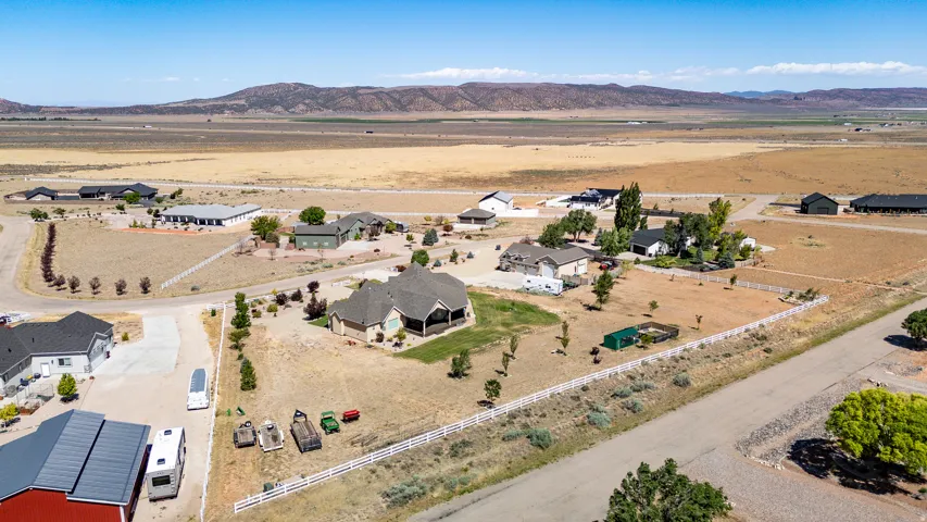 Expansive property with a single-story residence featuring a covered patio, a white picket fence, and mature landscaping