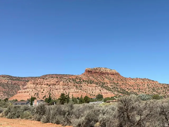 Desert landscape with expansive red rock formations and natural brush