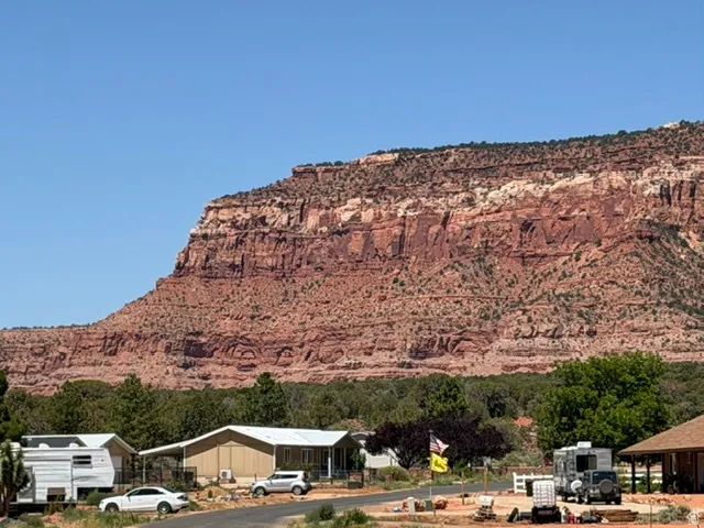 Red rock mountain backdrop with sparse green vegetation