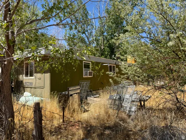Single-story structure featuring a green corrugated metal exterior and white-framed windows