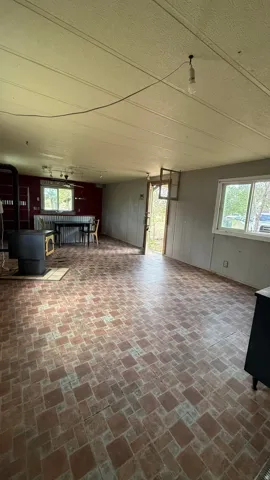 Spacious room with a wood stove and an open doorway