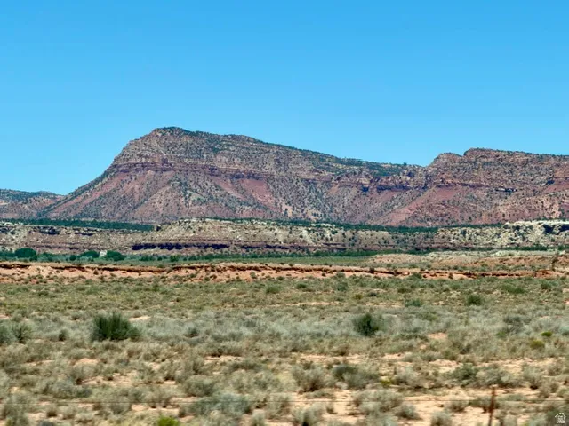 Expansive desert terrain featuring distant mesas and rolling hills
