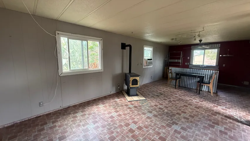 Wood-burning stove with a tiled hearth, two windows, and patterned flooring