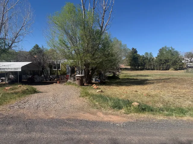 Manufactured home with a gravel driveway and an attached carport