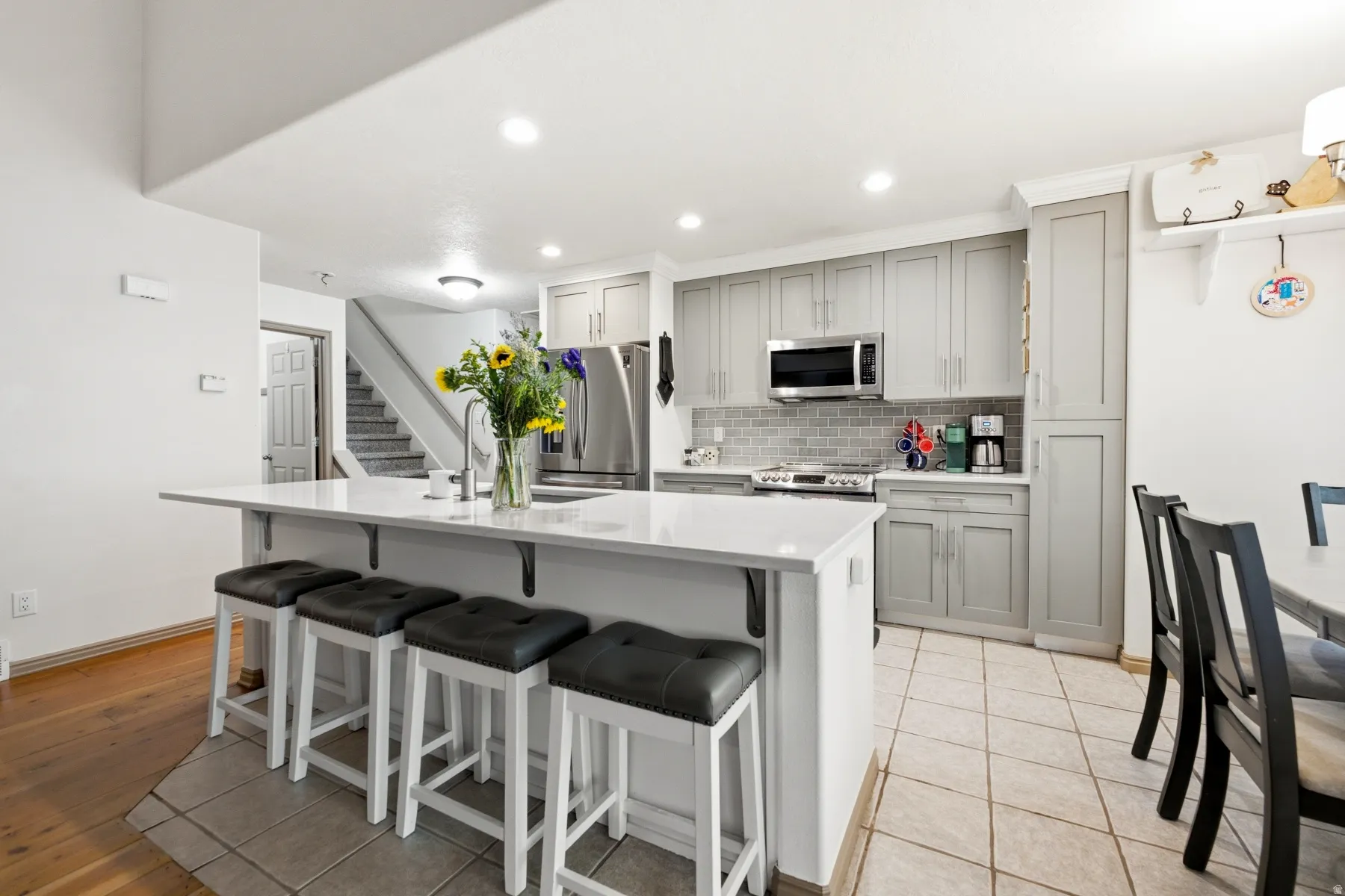 Contemporary kitchen featuring a white countertop island, recessed lighting, and stainless steel appliances