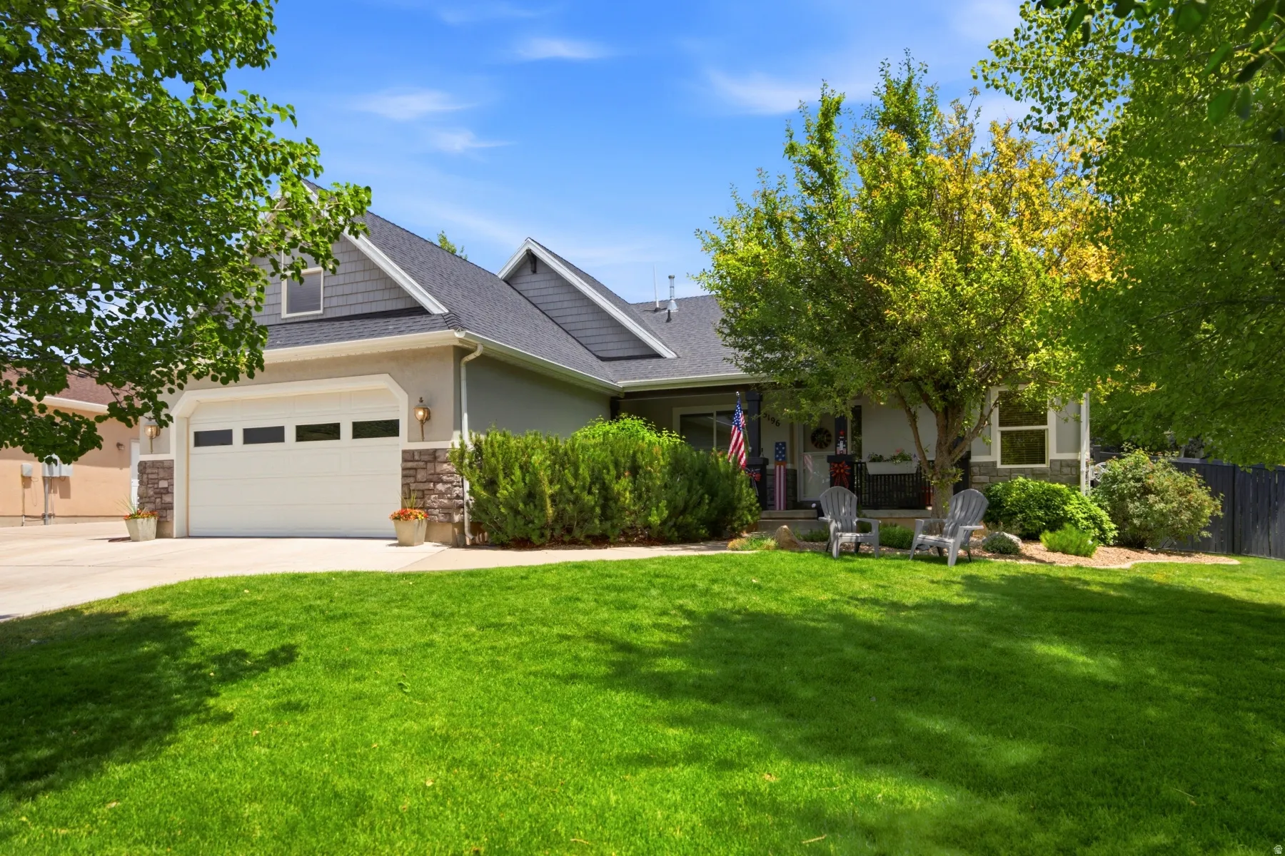 Exterior featuring a two-car garage, stone accents, and a covered front porch