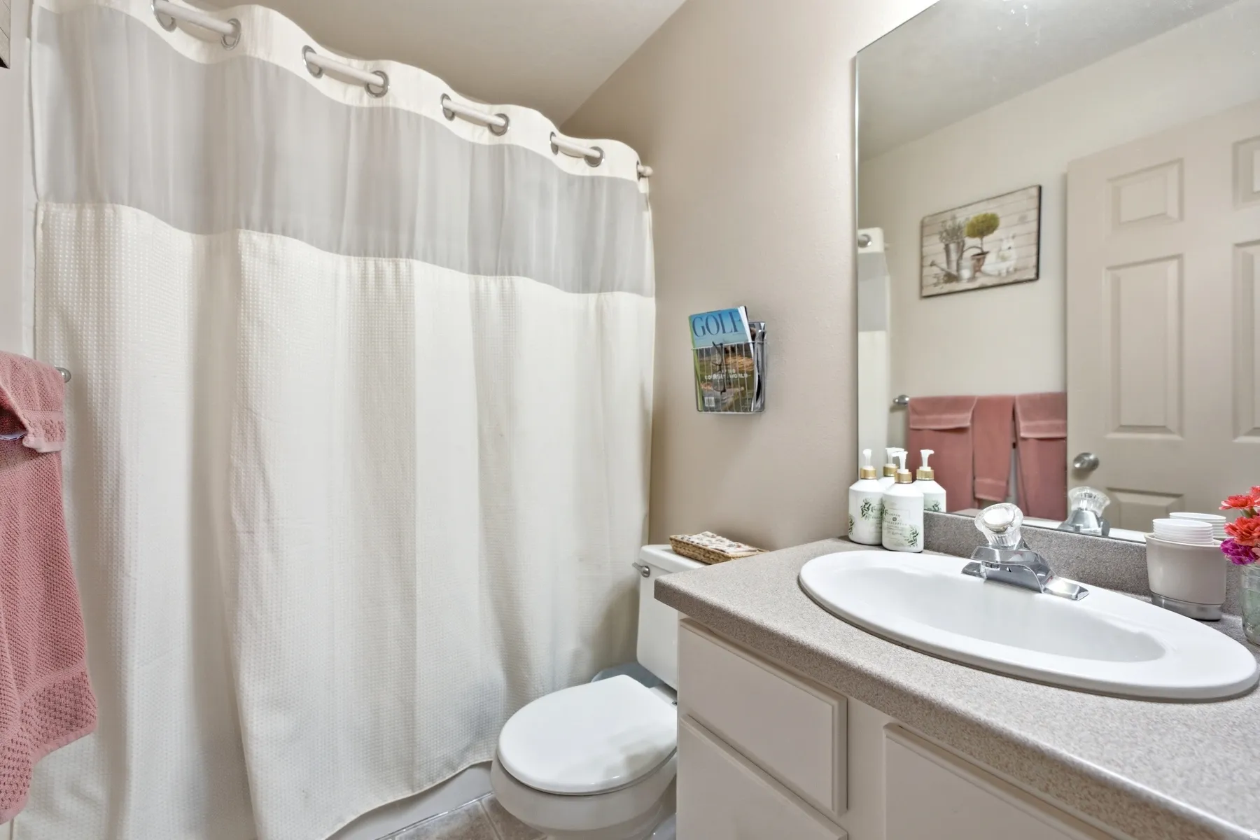 Additional Main floor Bathroom featuring an integrated sink vanity with a light-toned countertop, a large wall-mounted mirror, and a toilet