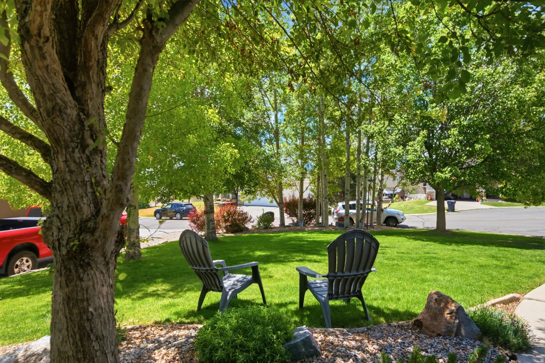 Expansive lawn area featuring mature trees providing ample shade