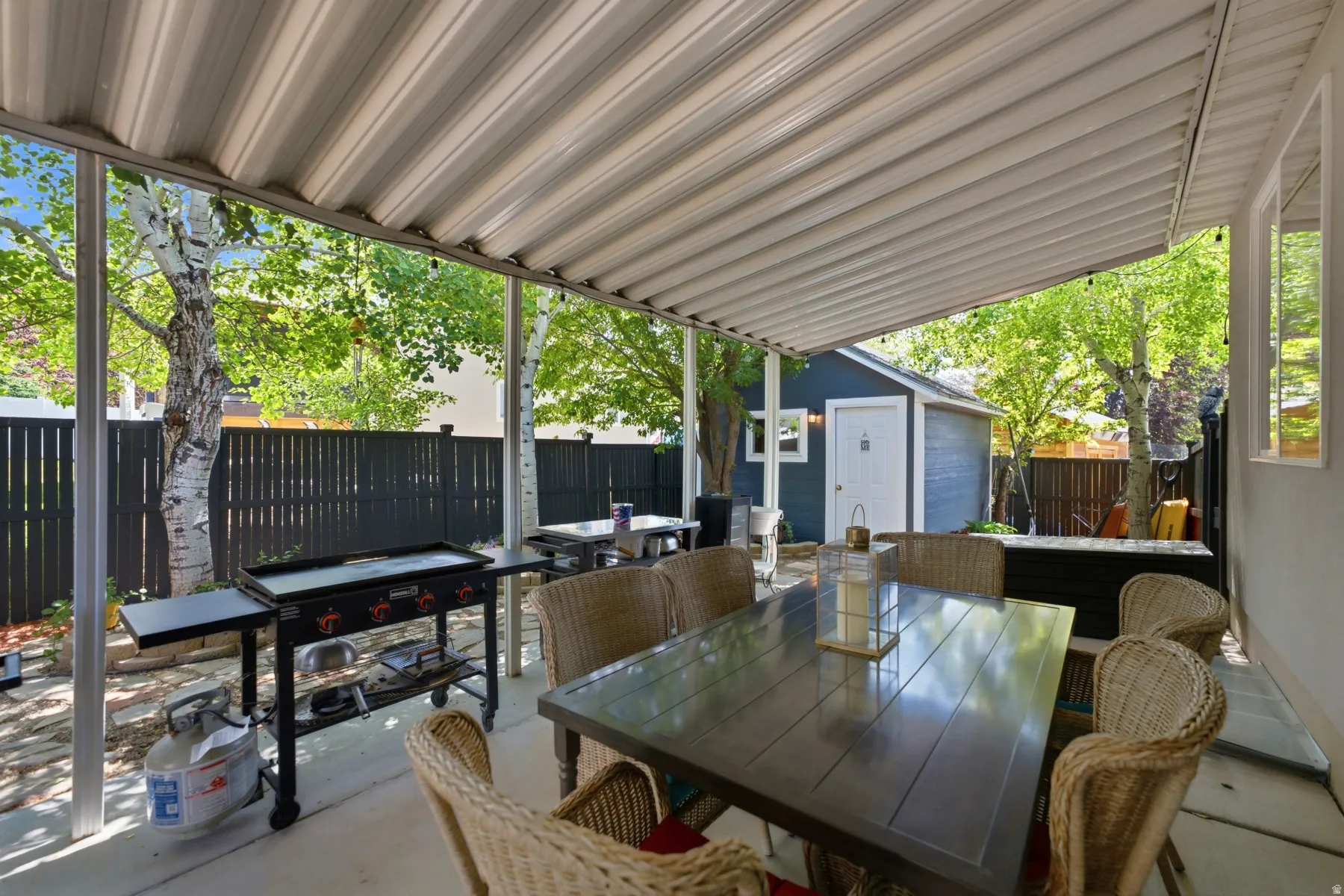 Covered patio area featuring a corrugated metal roof and concrete flooring