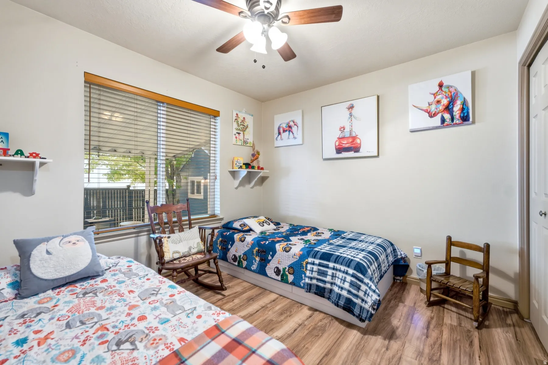 Bright room featuring wood-finish flooring and a ceiling fan with integrated lighting