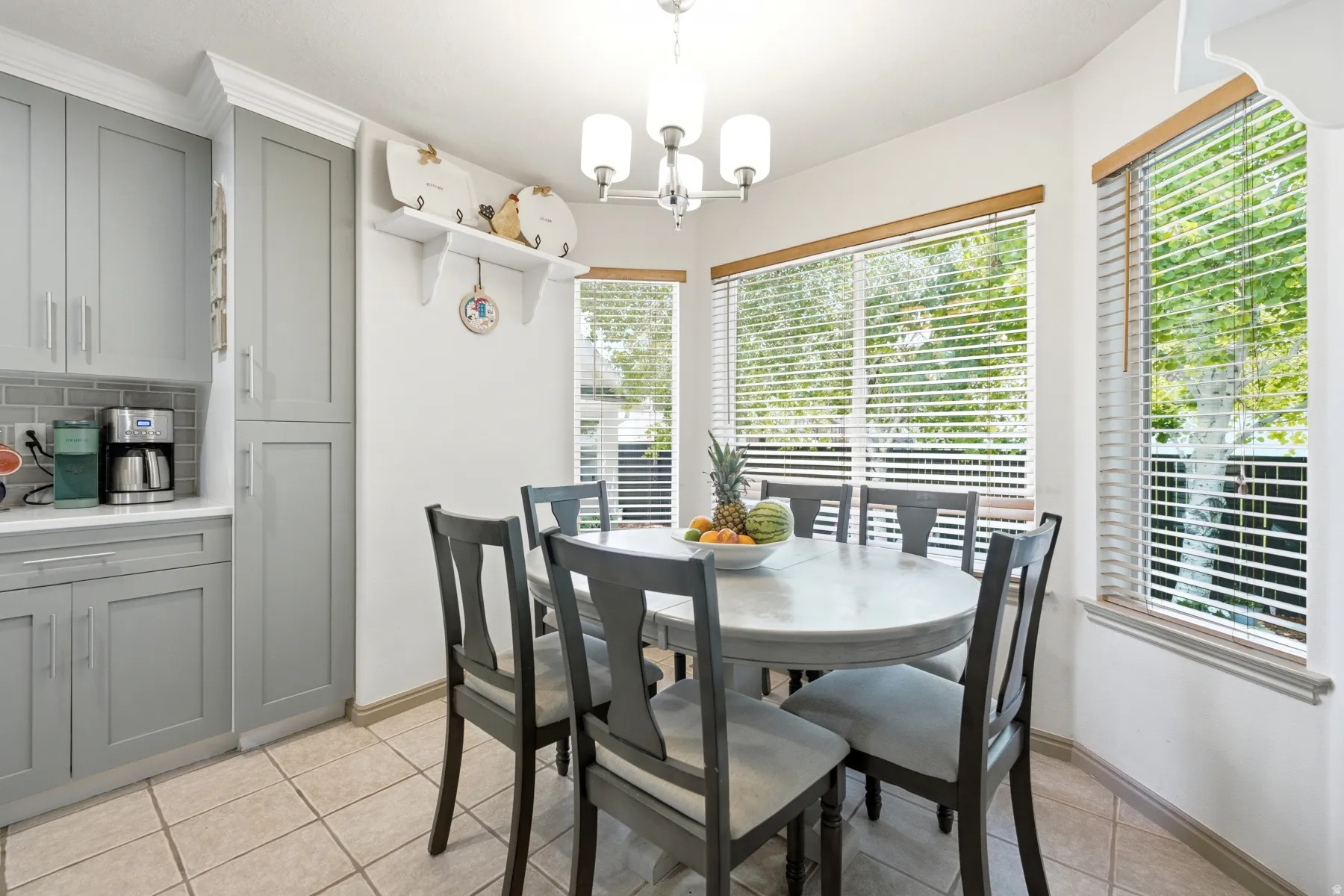 Dining area featuring large windows, a chandelier, and tile flooring