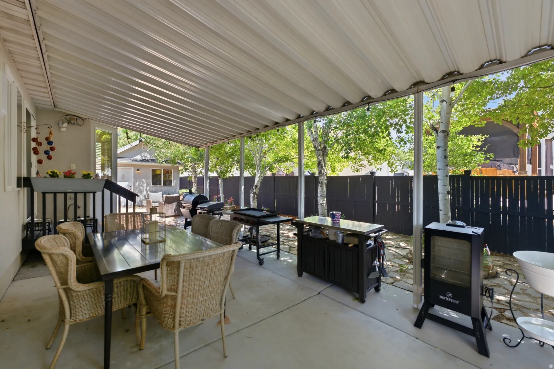 Covered patio featuring concrete flooring and a solid roof structure