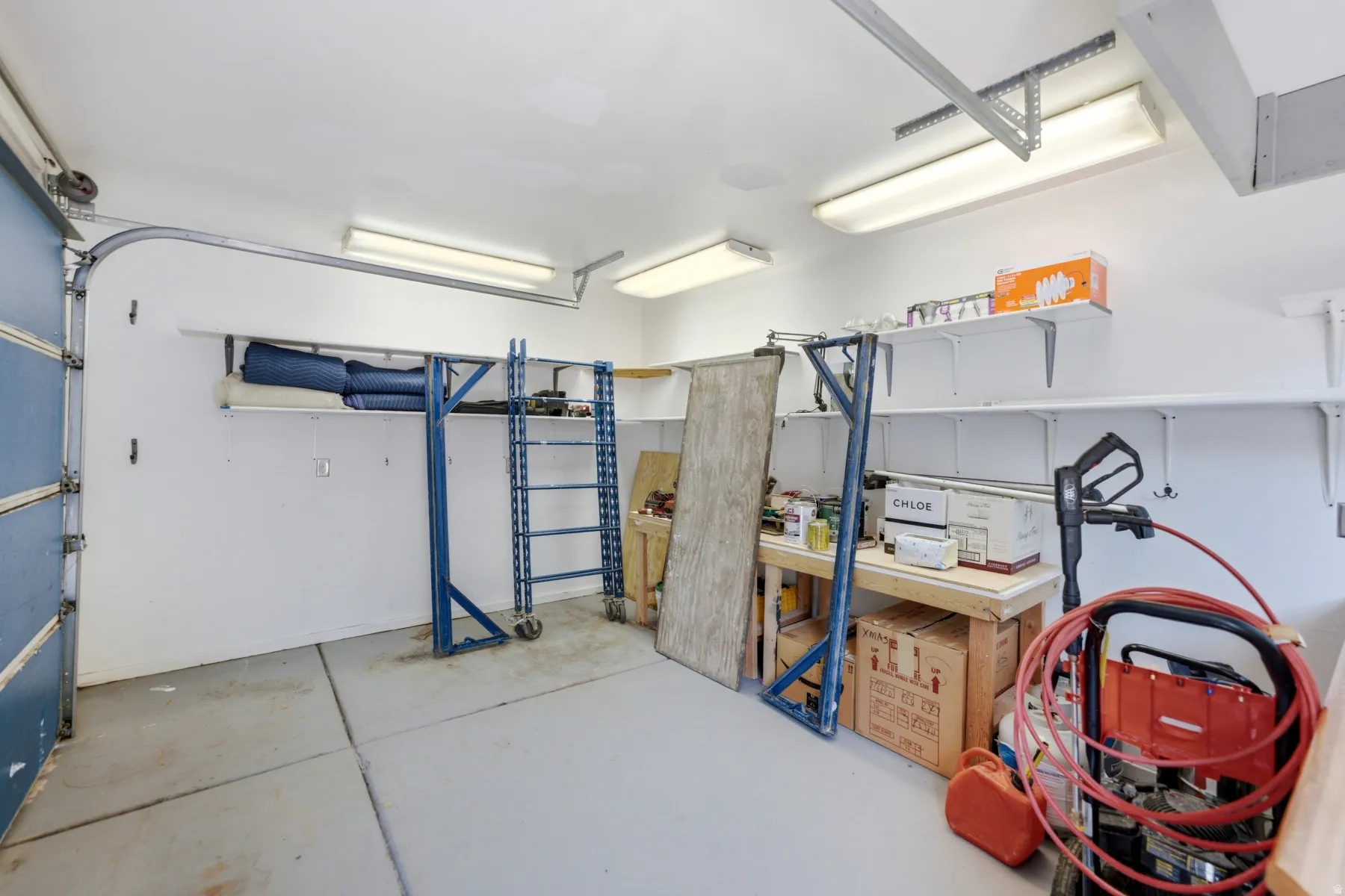 Spacious garage featuring a light gray concrete floor and white walls