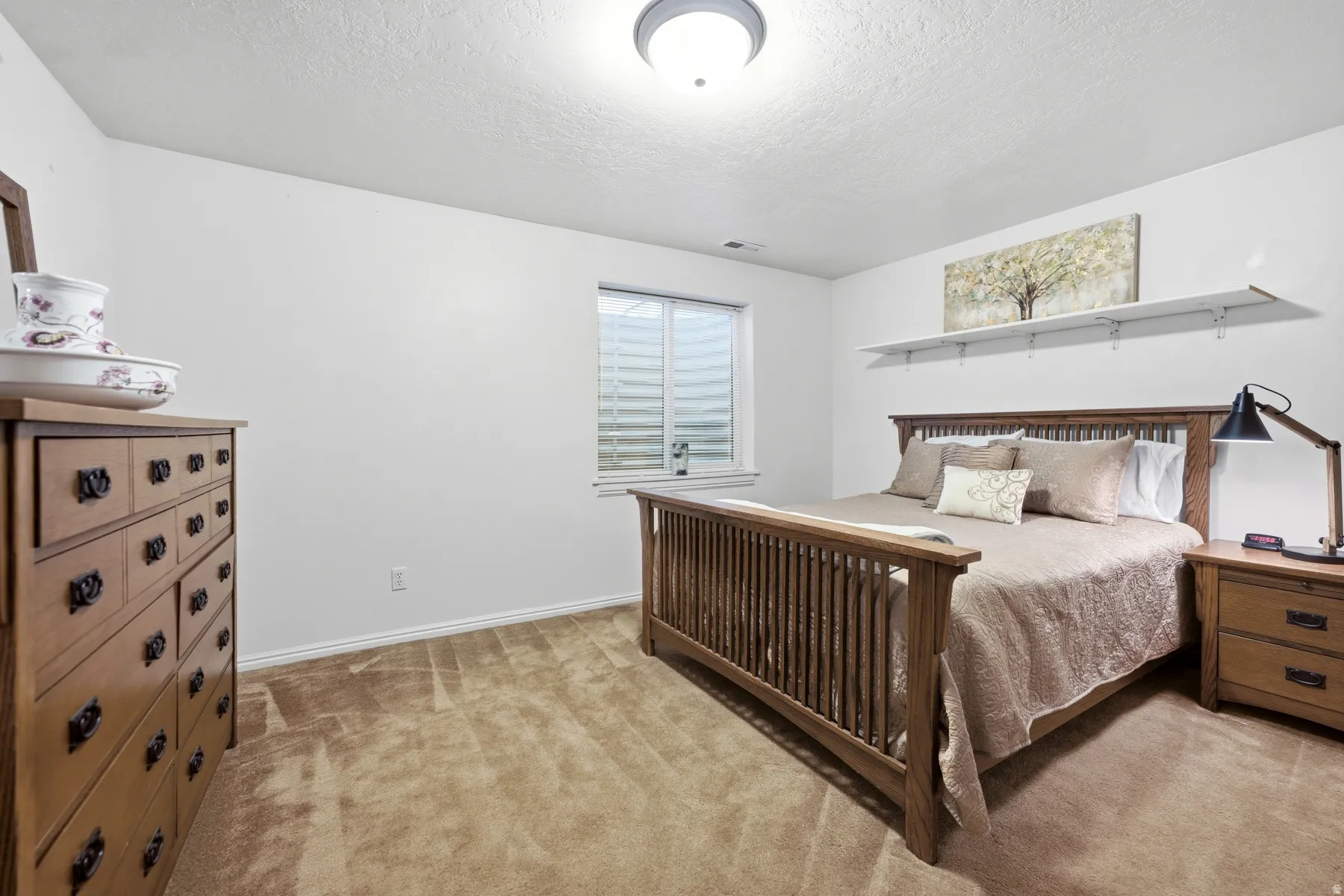 Carpeted room featuring a window with horizontal blinds, white baseboards, and a semi-flush mount ceiling light fixture