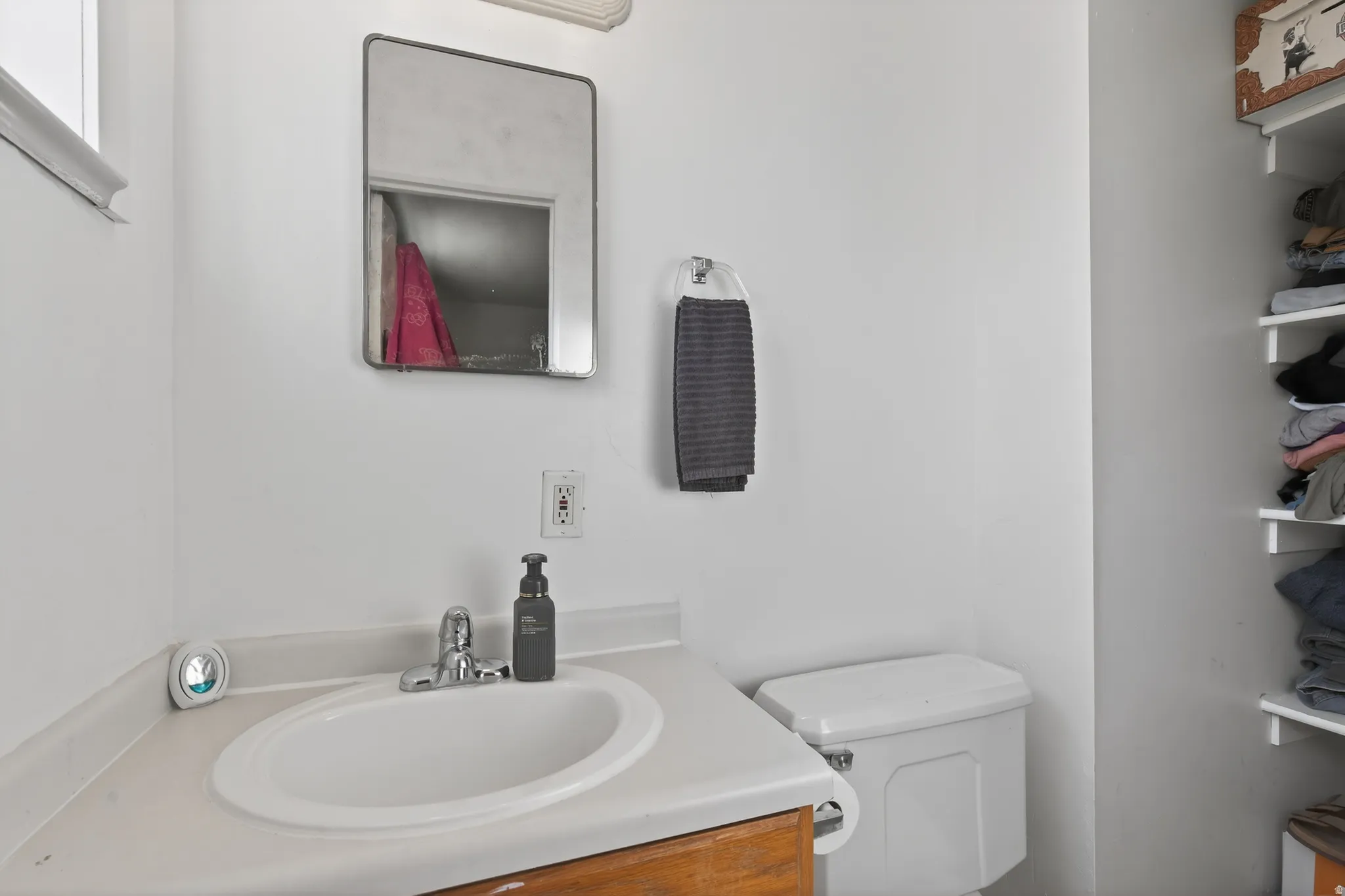 Bathroom featuring a white sink basin, chrome faucet, and rectangular mirror